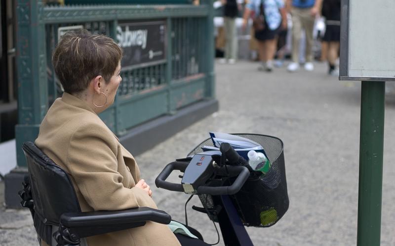 vrouw wacht in scootmobiel bij bushalte vrouw wacht in scootmobiel bij bushalte