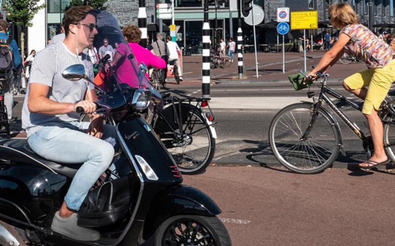 man op scooter in drukke straat