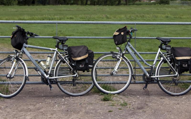 twee fietsen tegen een hek voor een weiland