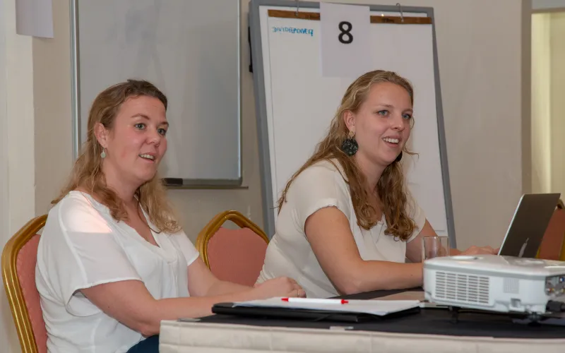 Twee collega's van de Nationale ombudsman, zittend achter een tafel