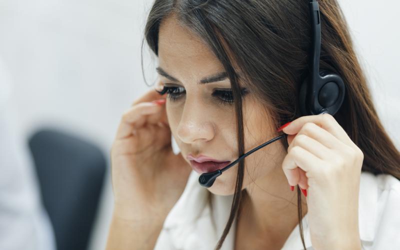 Vrouw met headset aan de telefoon Vrouw met headset aan de telefoon