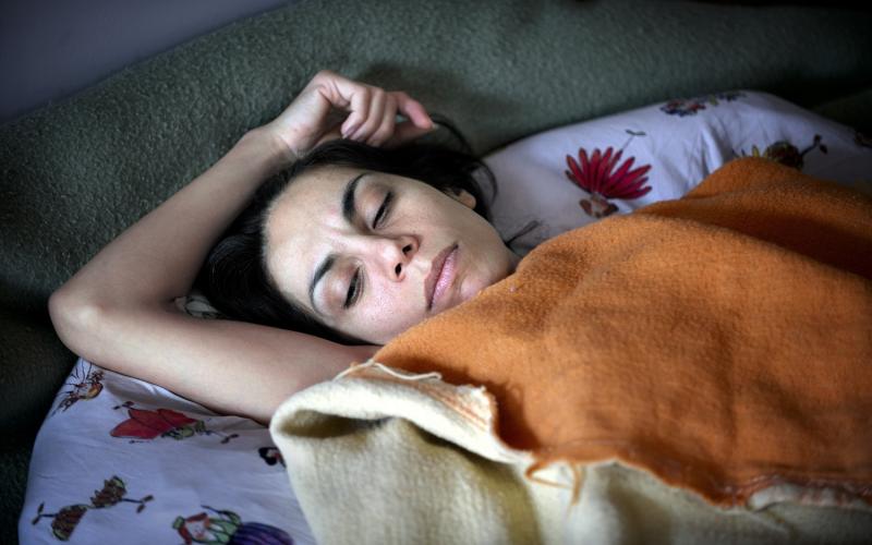 Foto van een vrouw onder de dekens in bed