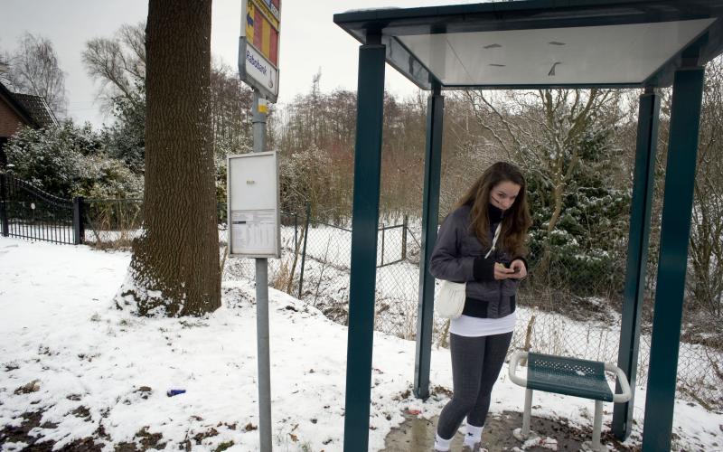 Foto van een meisje in een bushokje