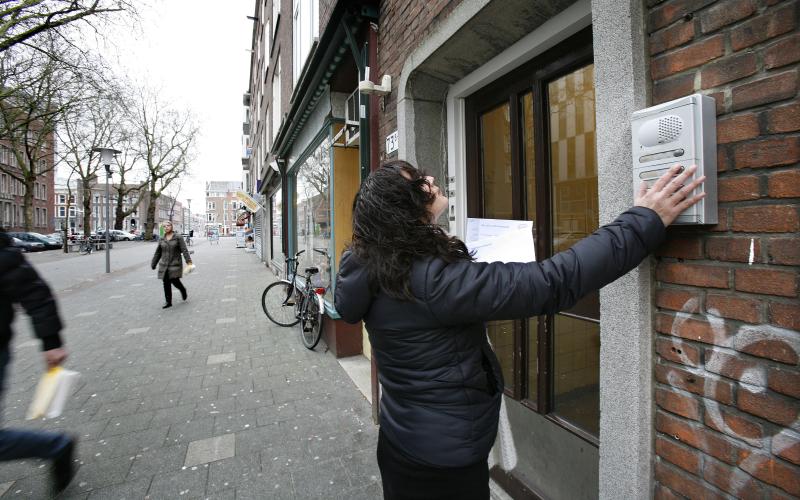 Foto van een deurwaarder die aanbelt bij een huis