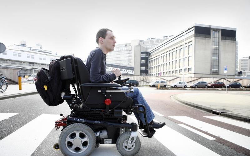 Foto van een jongen in een rolstoel op een zebrapad Foto van een jongen in een rolstoel op een zebrapad
