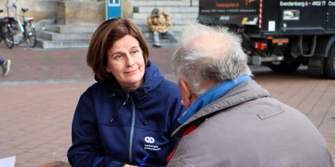 Een medewerker van de Nationale ombudsman in gesprek met een man op straat