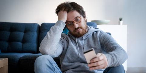 Man zit teleurgesteld op de grond voor zijn bank.