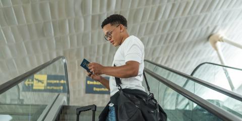 Jonge man op vliegveld kijkt naar paspoort