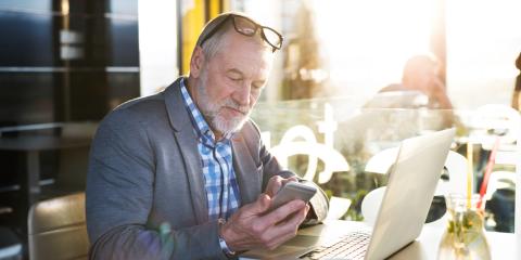 Senior man zit te werken en achter zijn laptop