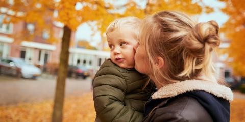 Moeder heeft zoon vast en staan op straat in de herfst