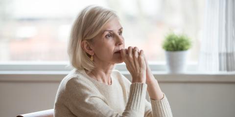 Senior vrouw kijkt bedenkelijk voor zich uit