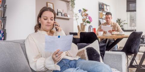 vrouw met brief in hand aan de telefoon