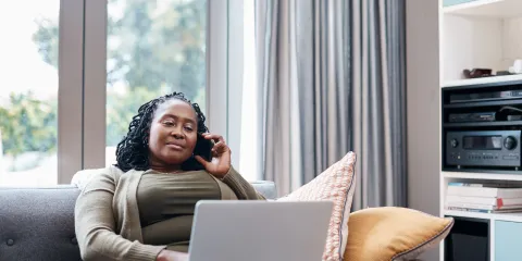 Vrouw regelt zaken met computer en is aan de telefoon