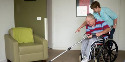 man in rolstoel met huishoudelijke hulp