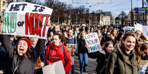 een grote groep mensen demonstreert in Amsterdam