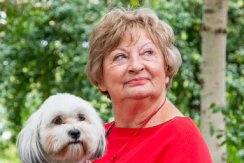 Oudere dame met hondje op schoot