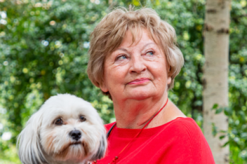 Oudere dame met hondje op schoot