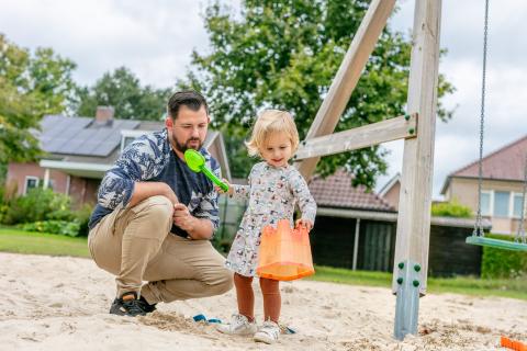 Vader speelt met dochter in de speeltuin