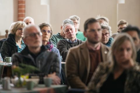 Groep inwoners van Loppersum (Groningen) luistert naar iemand bij een bijeenkomst