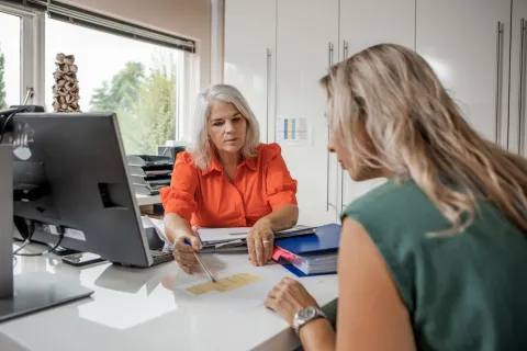 twee vrouwen in gesprek aan een bureau