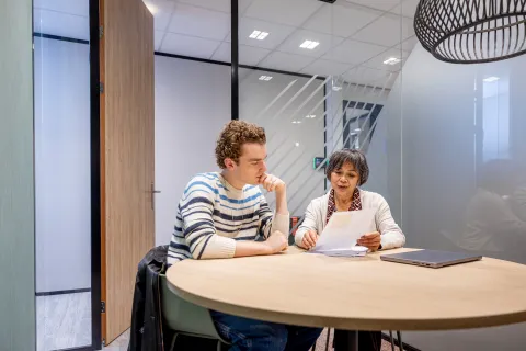 Twee mensen in overleg in kantoorruimte