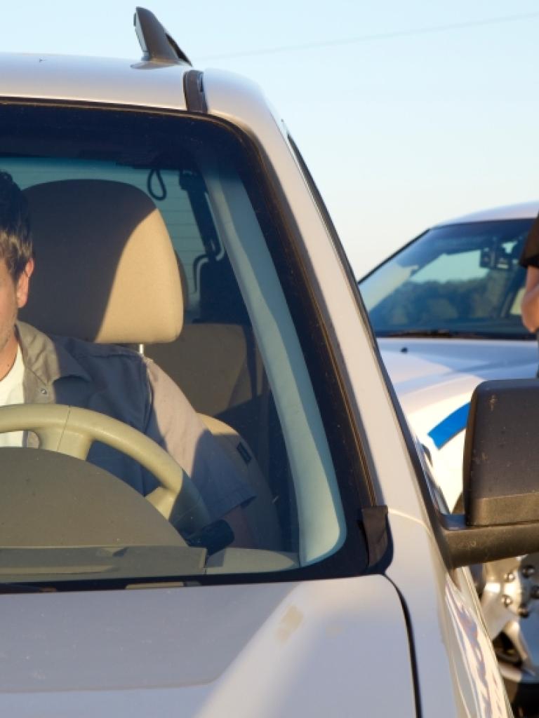 Foto van een agent bij een auto met bestuurder