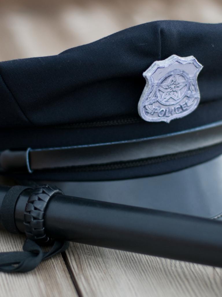 Foto van de pet van een agent en een wapenstok