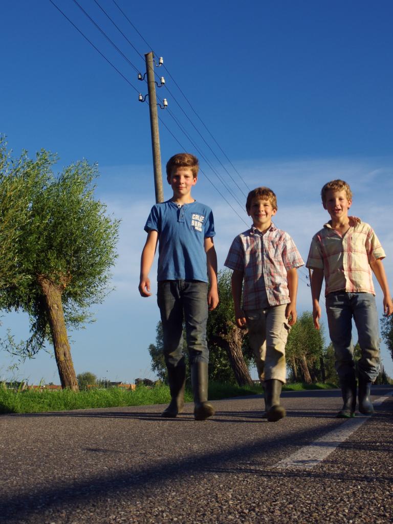 Drie jonge jongens wandelen over straat
