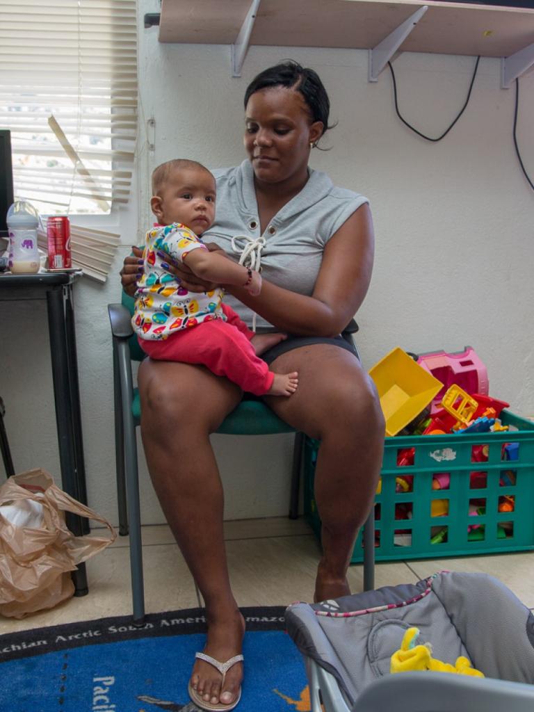 Moeder zit met kind op schoot in huis op Saba