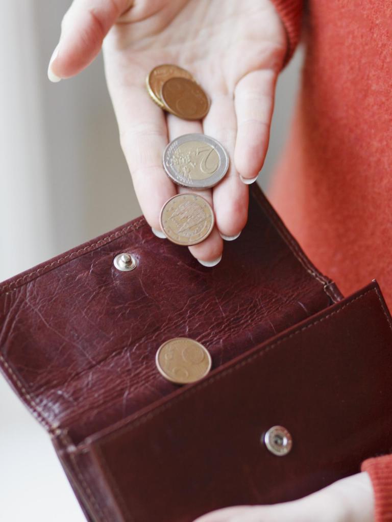 Portemonnee waar muntjes in worden gedaan door een vrouwelijke hand