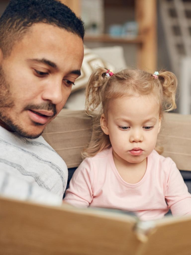 Vader leest boek met dochter