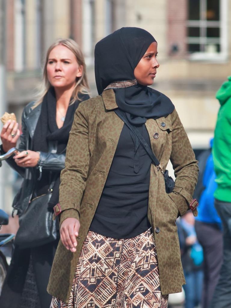 Zwarte vrouw met hoofddoek in een drukke straat