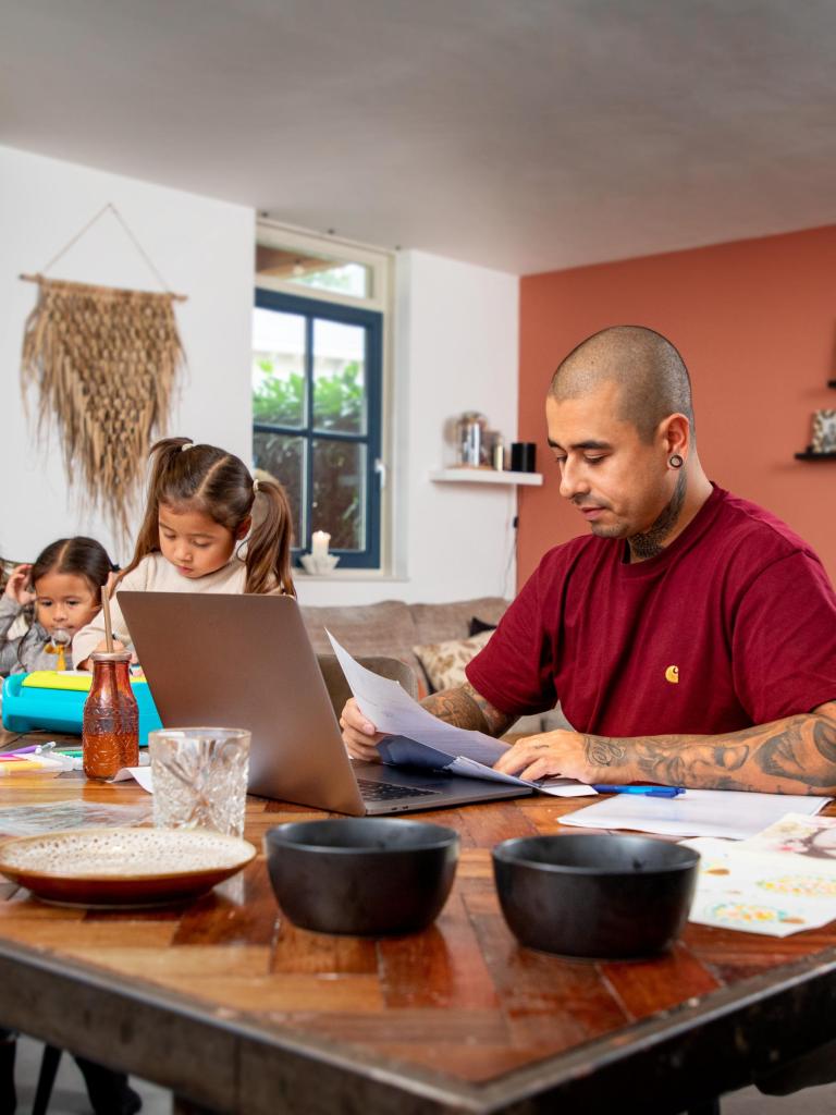 Jong gezin regelt thuis zaken achter laptop 