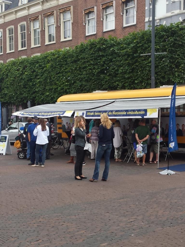Foto van de gele Ombudsbus op de markt in de provincie Drenthe