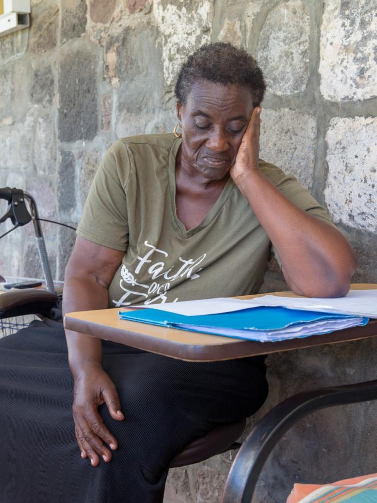Caribische vrouw zit aan tafel en leest document