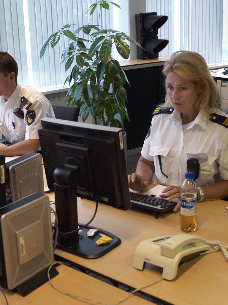 Foto van politieagenten achter een computer