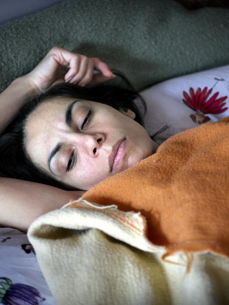 Foto van een vrouw onder de dekens in bed