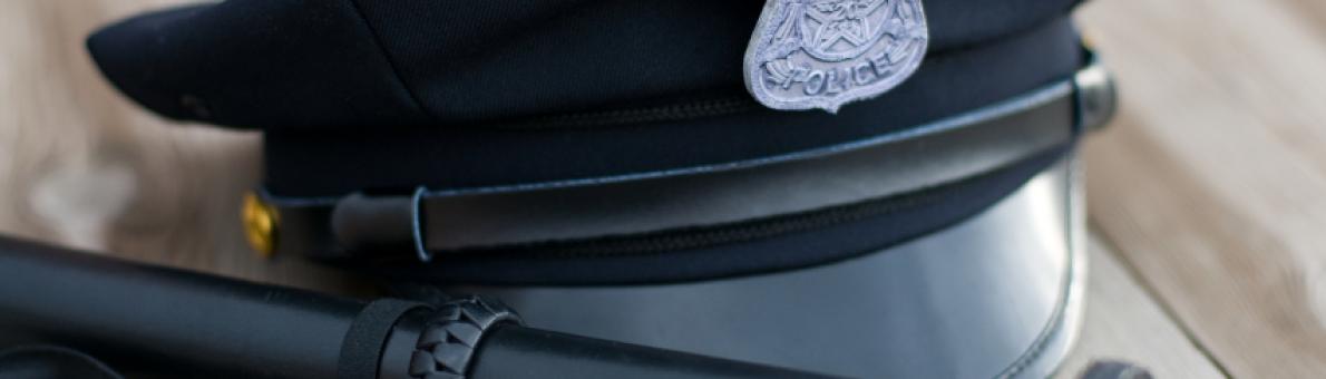Foto van de pet van een agent en een wapenstok