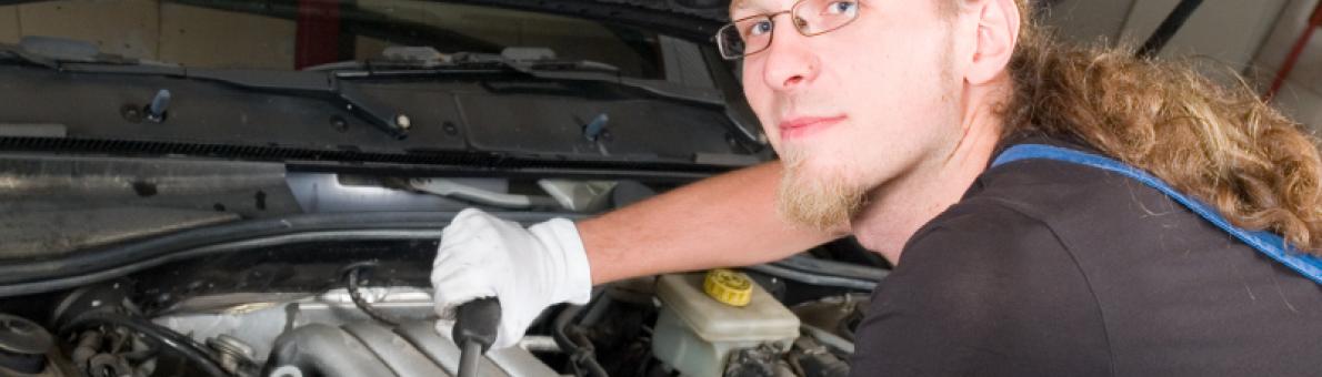 Man sleutelt aan auto