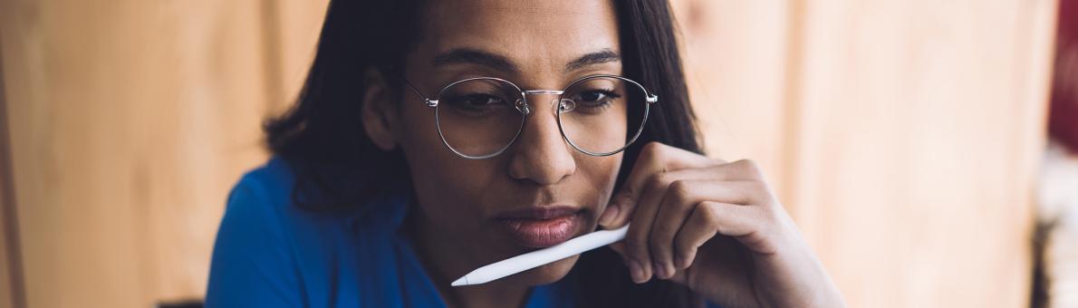 Vrouw met bril en tablet pencil in haar hand kijk op haar tablet of computerscherm. Ze is aan het werk. Vrouw met bril en tablet pencil in haar hand kijk op haar tablet of computerscherm. Ze is aan het werk.