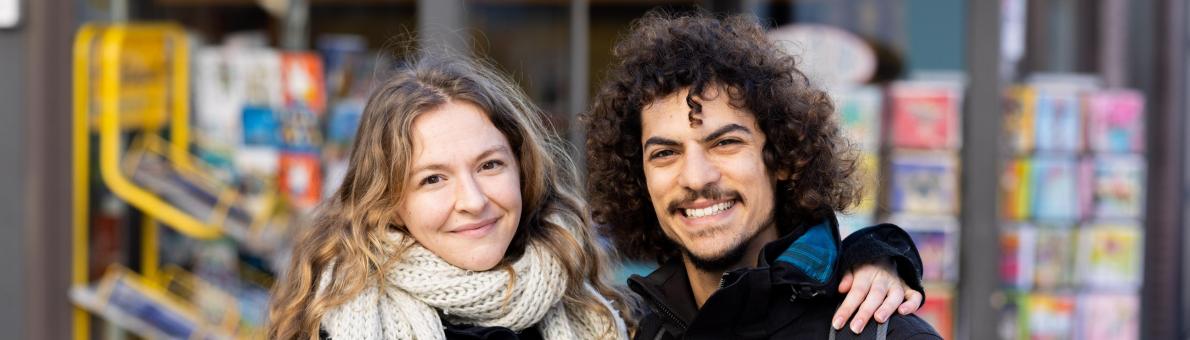 Mette, een studente met blond haar met haar vriend op de foto. Hij heeft donkere krullen.