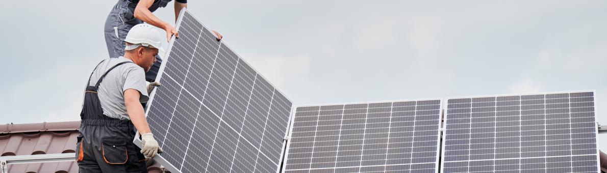 Twee mannen staan op een dak zonnepanelen te monteren