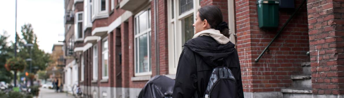 Jonge vrouw loopt in Den Haag in de regen