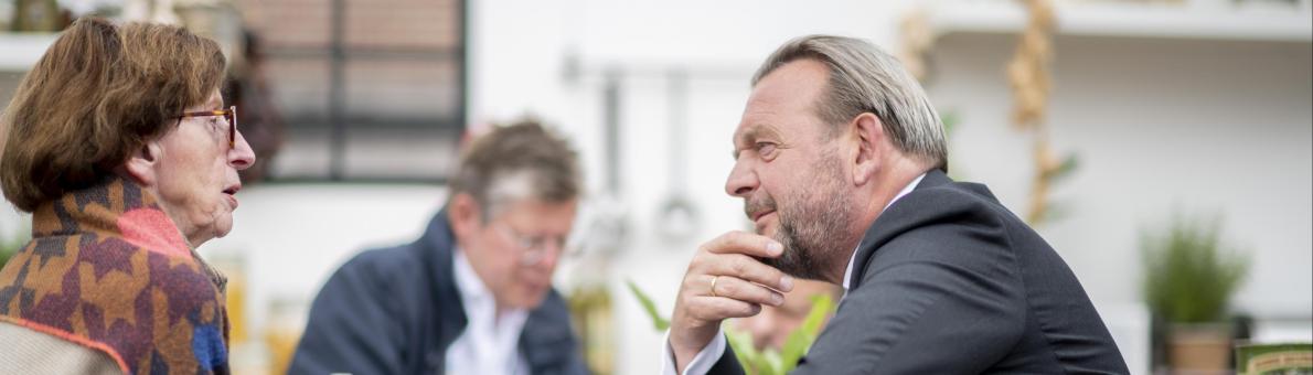 Een oudere dame in gesprek met de Nationale ombudsman Reinier van Zutphen (een man van middelbare leeftijd) Een oudere dame in gesprek met de Nationale ombudsman Reinier van Zutphen (een man van middelbare leeftijd)