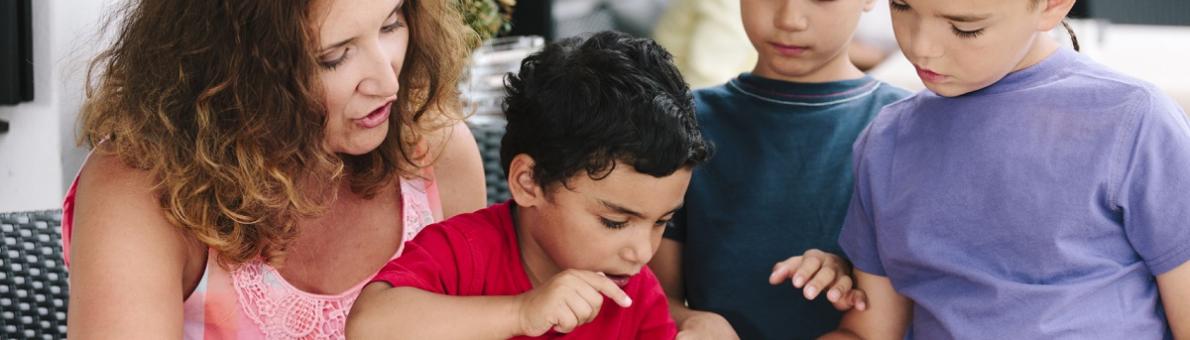 moeder met drie zoons kijken op de tablet