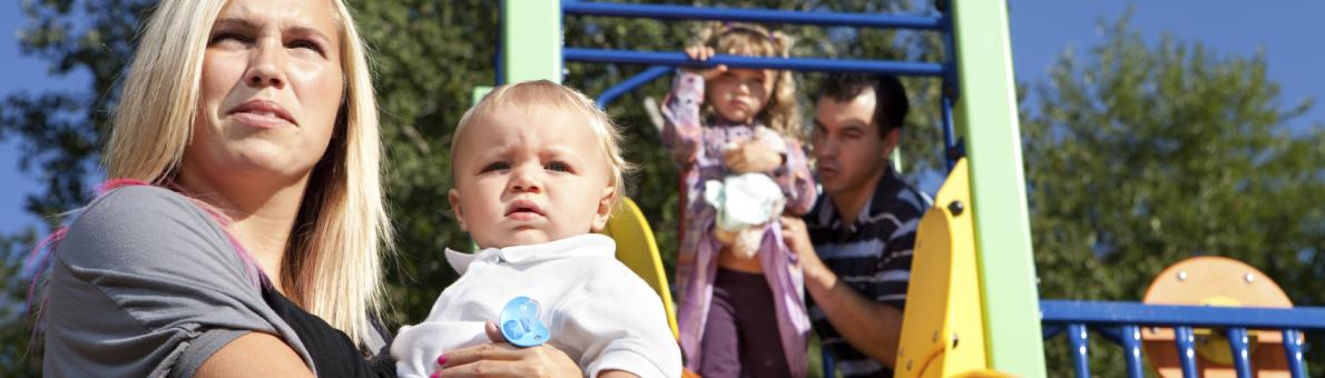 Ouders met kinderen in speeltuintje