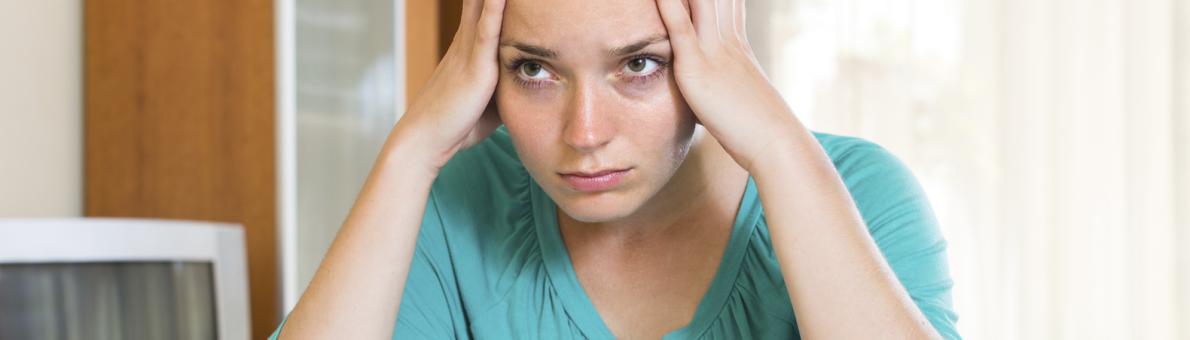 Vrouw heeft haar handen onder haar hoofd en staart voor zich uit