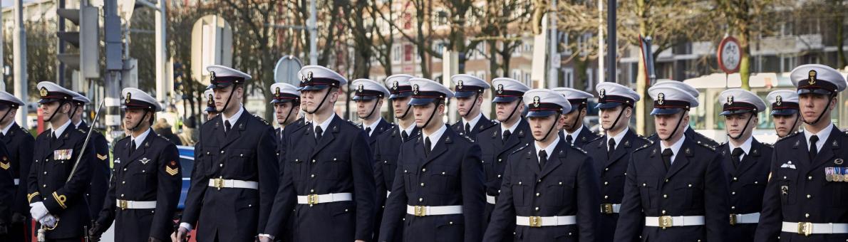 Het Korps Mariniers in uniform. Een groep van meer dan twintig marinier staan in twee rijen opgesteld.