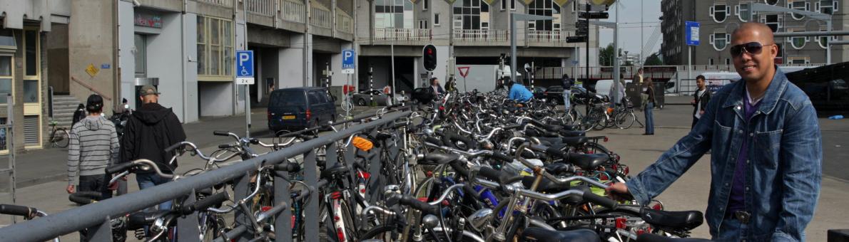 man met fiets bij kubuswoningen in Rotterdam