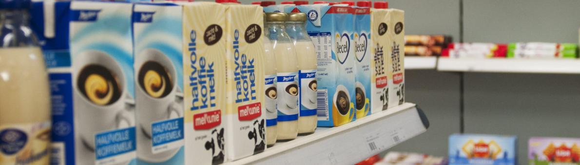 Een winkelschap met pakken houdbare melk 